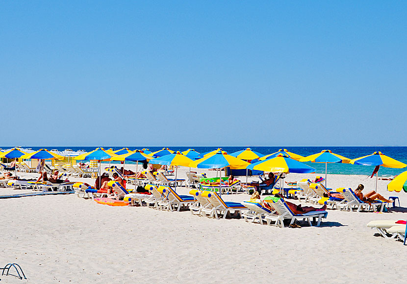 Hyra solstolar och parasoll på stranden i Marmari.