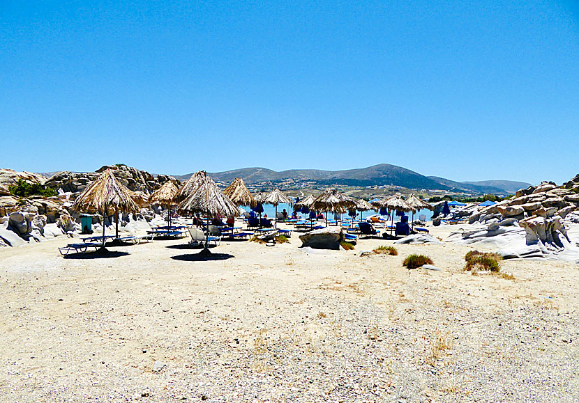 Dyra solstolar och parasoll för uthyrning vid sandstranden Kolymbithres.